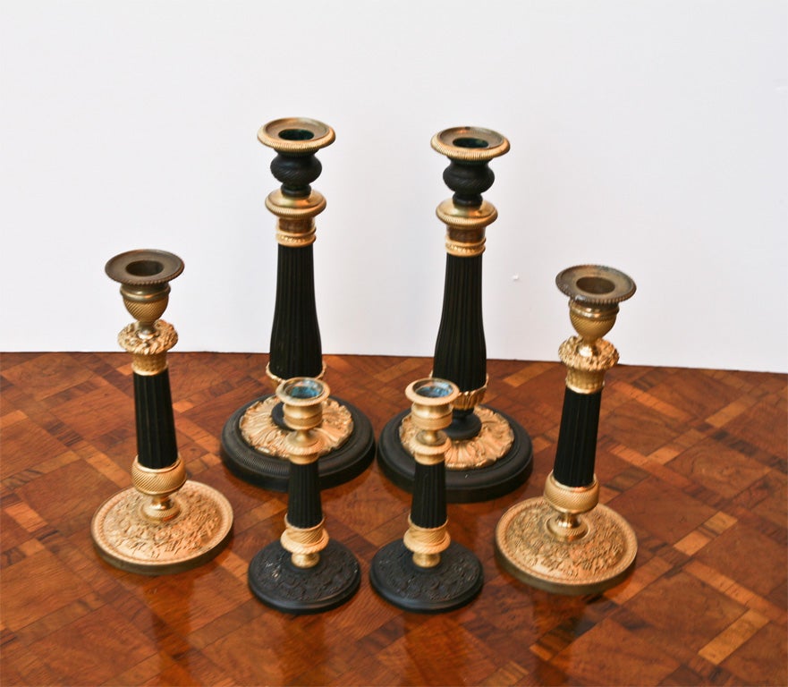 A very nice collection candle sticks in gilt and paitinated bronze of three different sizes. Each pair is of very fine quality and each pair are in very good condition. The collection would be all that was needed to decorate a room and give it a
