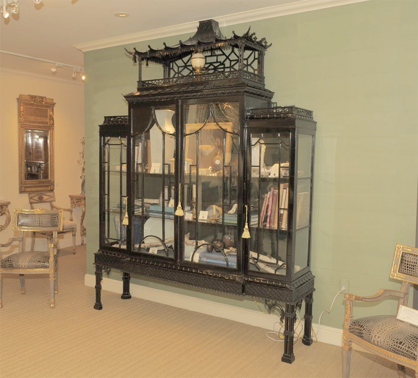 Early 20th Century Beautifully Hand Carved Lacquered Display Cabinet on Stand in the Chinese Chippendale Taste, the Pagoda Top with Stylized finial Hanging Tassles Above an Open Tracery Fretwork with Four Cabinet Glass Doors with Decorative Mullions