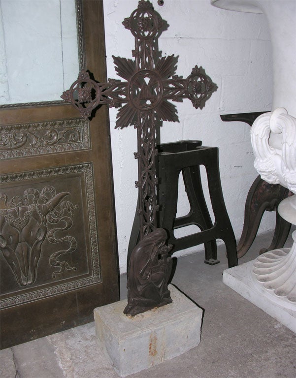 French, cast-iron cross on stone base. The decoration includes a bas-relief of the lamenting Virgin Mary at the base of the cross.