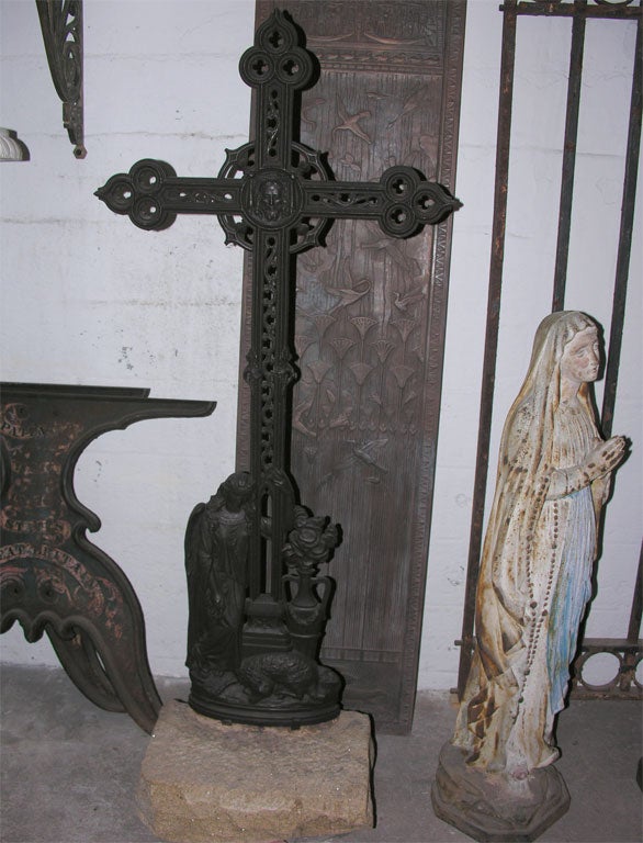 French cast-iron cross on original stone base. The decoration includes a relief of the Veil of Veronica, and a lamenting angel and a sleeping sheep at the base of the cross.
