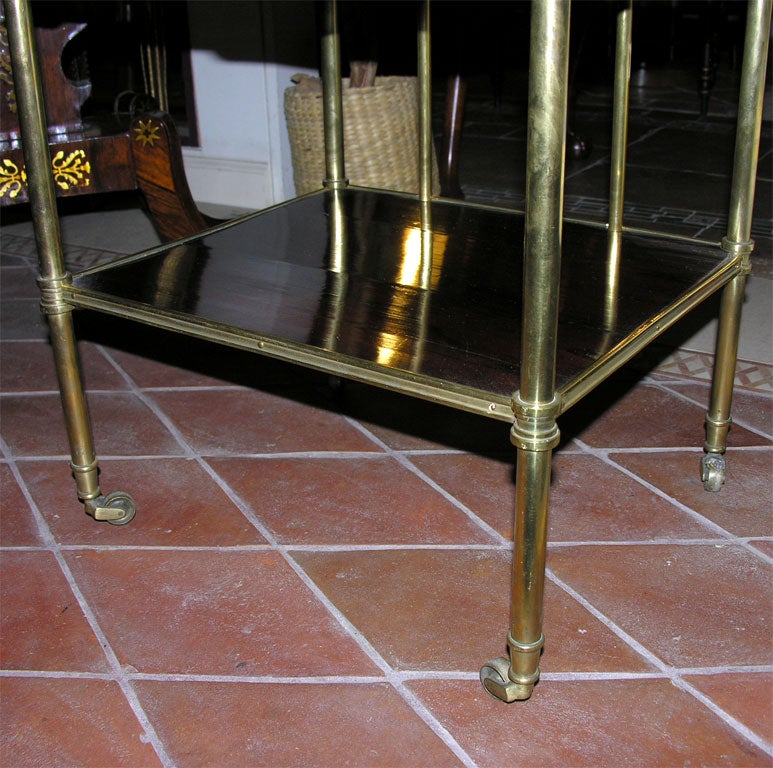 Regency brass and rosewood four tier etagere with brass ball finials on casters.