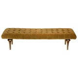 Upholstered bench with bronze supports