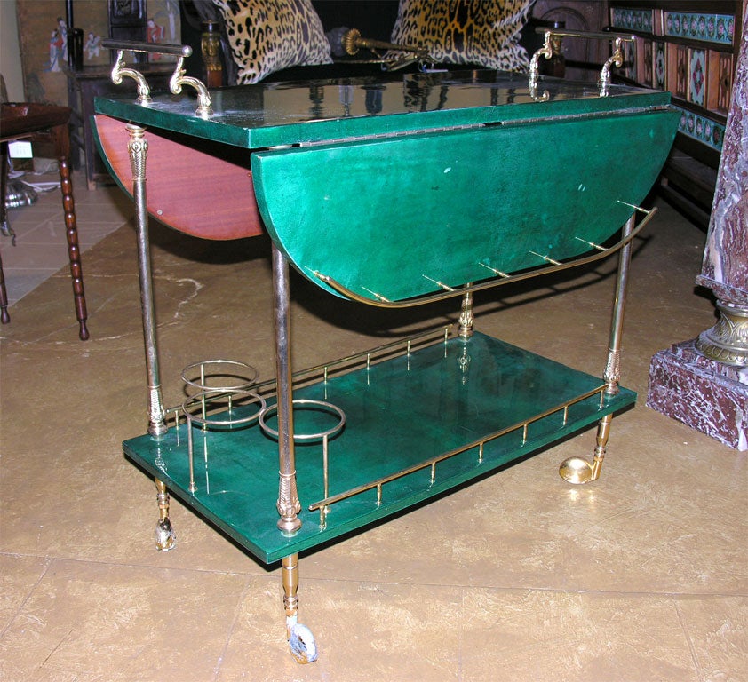 Aldo Turo emerald green lacquered goat skin bar cart with collapsible sides and brass hardware and gold leaf wheels.