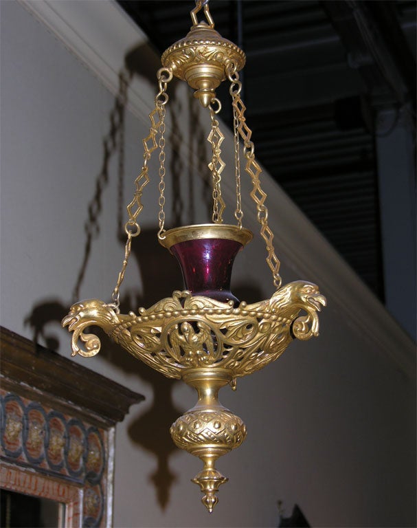 Napoleon III gilt bronze lantern with handblown ruby glass supended by chains surmounting a pierced body of heraldic birds and curvilinear design.