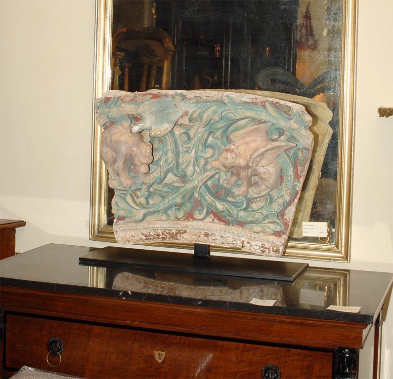 A large polychromed terra cotta Gothic Revival fragment from a building in southern France. Traces of gilding.  Mounted on a custom iron stand.