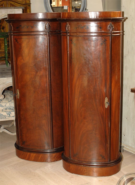 A pair of tall Danish Biedermeier mahogany oval column cabinets with ebony accents. Probably from the early 20th century. Nice large examples with good storage.