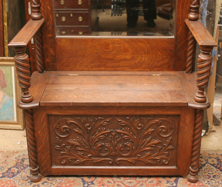 A good late 19th century American tiger oak hall bench with original fitted mirror, lift-up bench seat, and 6 hooks for clothes.