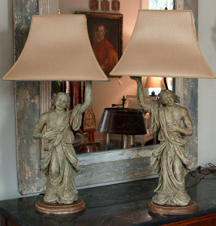 Handsome pair of 18thC hand carved wooden Italian angels with original painted surface now wired as lamps with silk stripe<br />
shades.