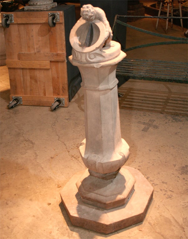 A Compton Pottery sundial, early 20th century.  The top in the form of a putto holding a hemisphere dial calibrated with hours all on a ribbed cylindrical column.<br />
<br />
                                                                       