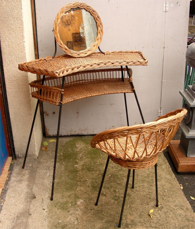 1950s wicker vanity table and chair on black metal base with round mirror. Chair height 70/50 cm., length 55 cm., depth 52 cm.