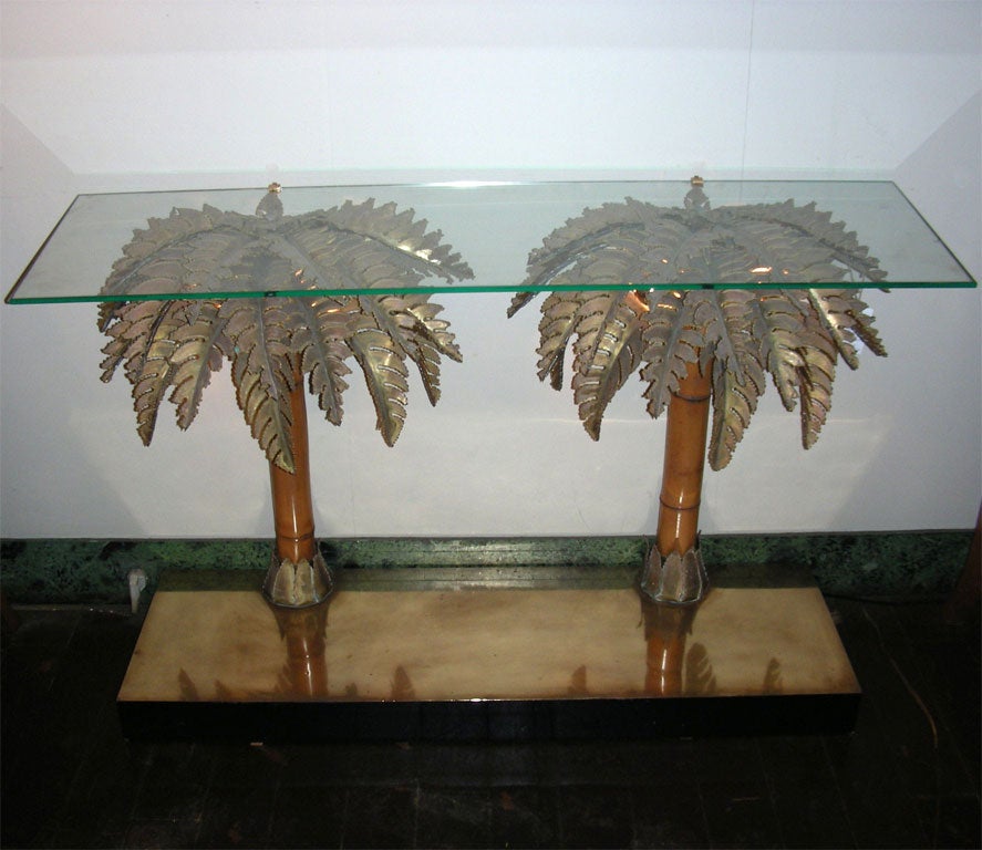 1970s console table made of two palm-trees with the trunk in bamboo and the leaves in gilt brass. Integrated light into the leaves. Top surface in glass and base in wood and gilt brass.