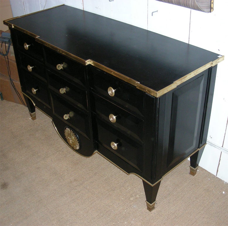 1940-1950 black commode in the style of André Arbus, with nine drawers. Gilt brass edges and sun on the apron.