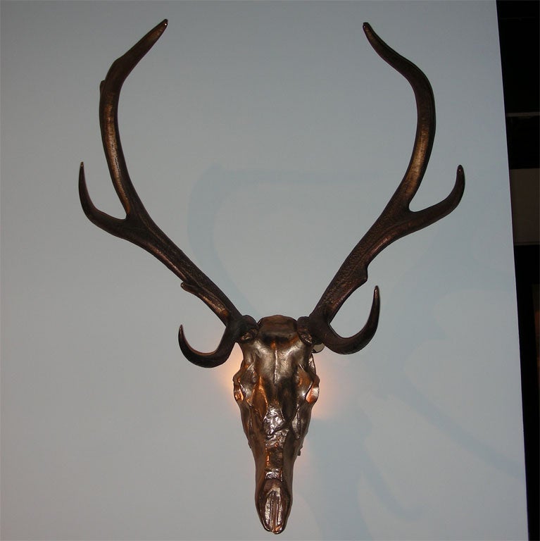 Two 1970s sconces shaped like a deer' skull with antlers. Light shines through the eye sockets.
BY Jacques Duval-Brasseur