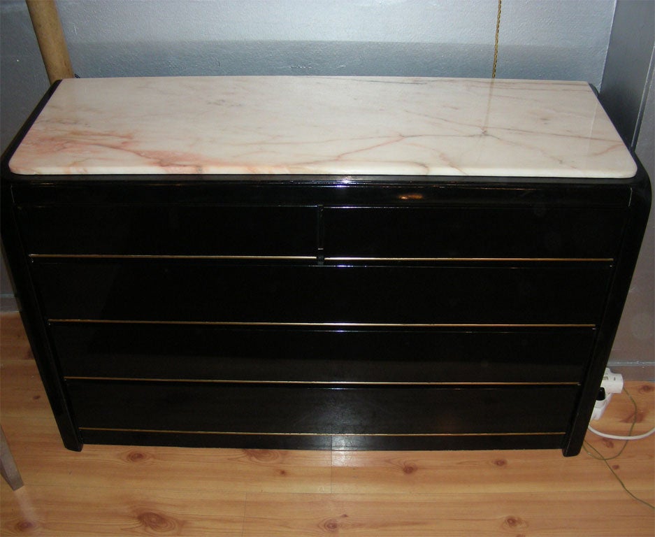 1970s Spanish commode in black lacquer, with five drawers and marble top. Gilt metal edging on base and drawers.