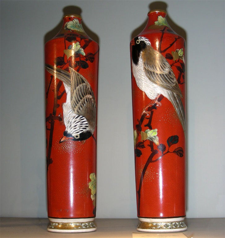 Two Japanese vases in red painted porcelain decorated with flowers and a nightingale, from the Meiji period.
