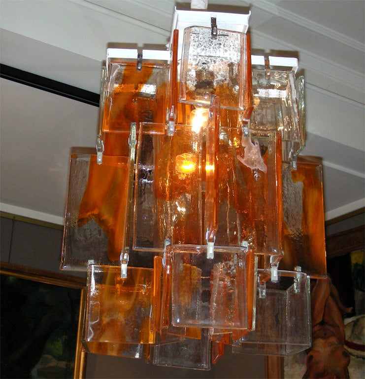 Lampadario in vetro di Murano arancione degli anni '60 composto da placche assemblate intorno a un fusto centrale a forma di tubo. Sono disponibili diversi pezzi, ma il prezzo indicato è per uno solo. Forse da Mazzega o Toso.