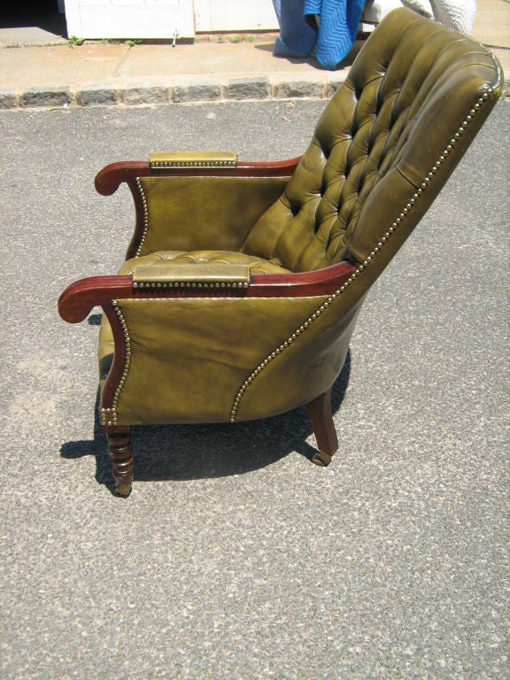 tufted arm , leather chair with side table attached. Buttoned seat and back.