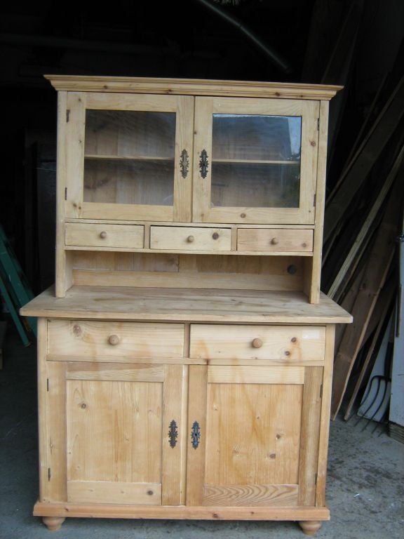 pine wood two piece cabinet with glass doors top.
