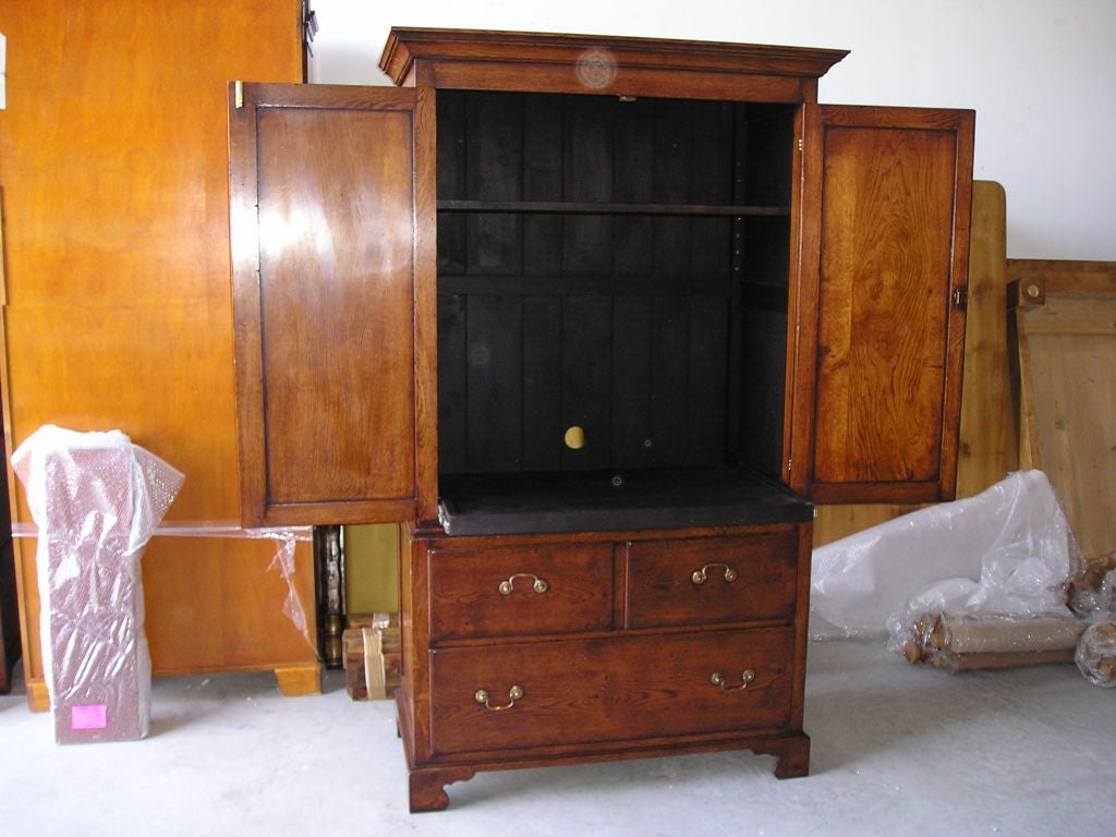 Oakwood armoire with two short drawers over one on bracket feet, with two doors. Custom-made in England.