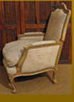 1850s French bergere. The hand-carved solid beechwood frame with foliate crest, canted cabriole legs, down filled conforming cushion, painted surfaces.