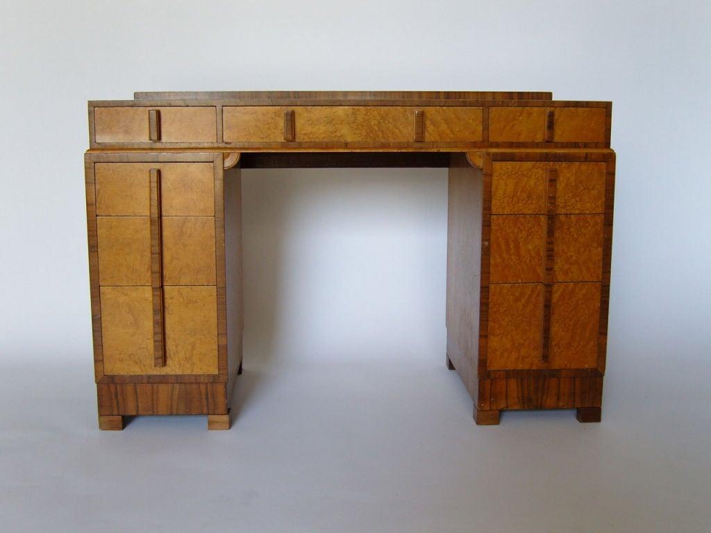 Bird's-eye maple and walnut Art Deco desk with nine drawers.
     