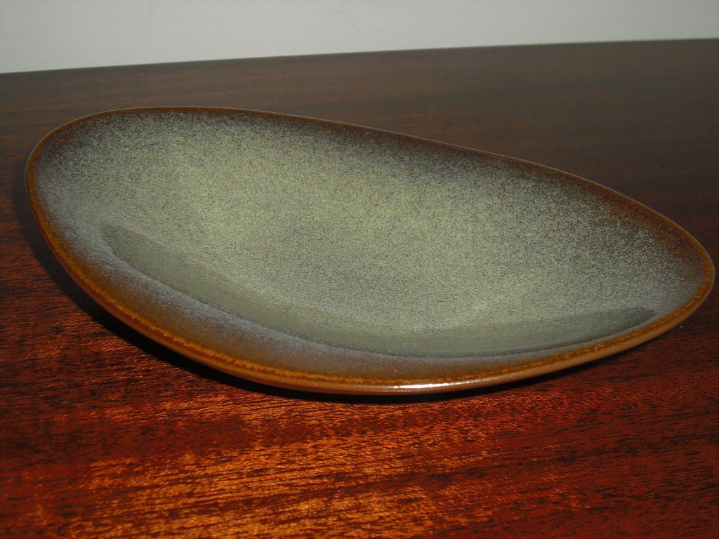 A low stoneware art pottery bowl by famed American potter, Rupert Deese. The bowl is chocolate brown and blue/green. Maker's mark and label.<br />
<br />
Rupert Deese was born in 1924 on the island of Guam. He achieved a B.A. at Pomona College in