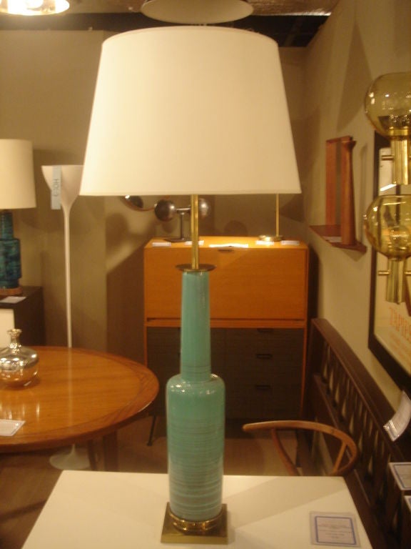 Green ceramic table lamp by Stiffel.  USA, circa 1950.<br />
<br />
Includes custom off-white parchment lampshade.<br />
<br />
Lamp measures 25 inches tall from base to top of ceramic neck; measures 34 inches from base to top of light bulb