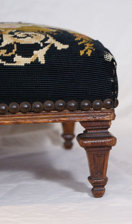 French Directoire footstool circa 1800 with interesting old needlepoint.