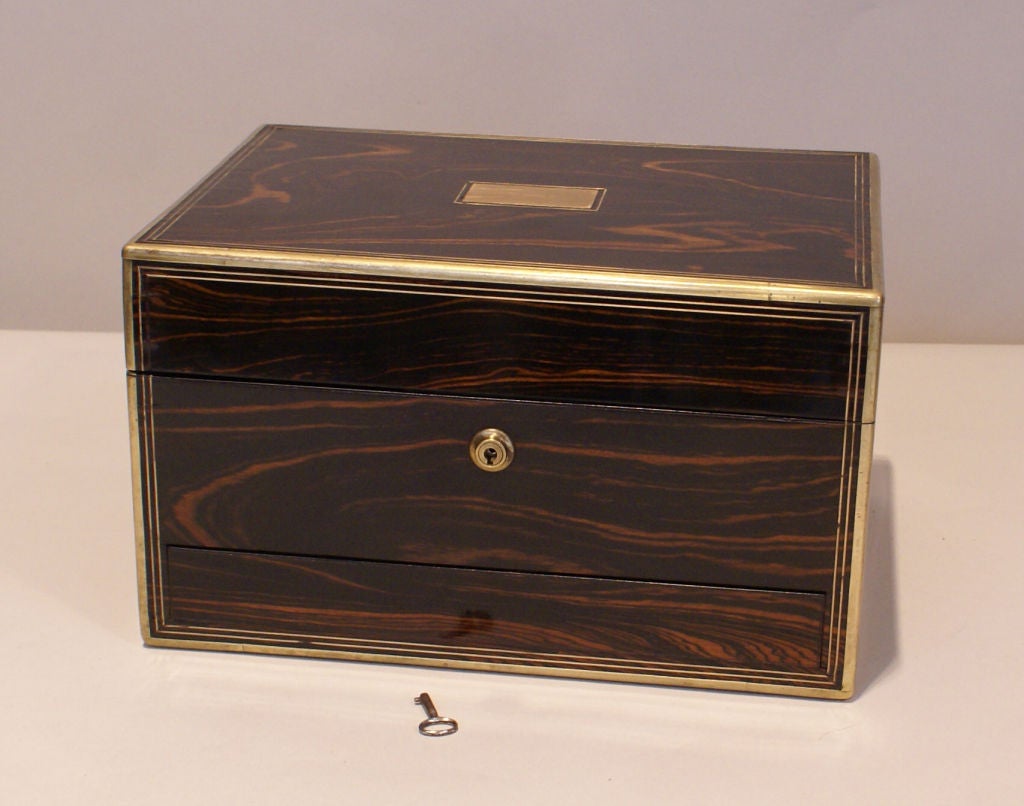 Rosewood jewelry box with mirrored and fitted interior; brass trim, inset plaque and recessed handles.  Bottom drawer lined as well. Comes with working key.