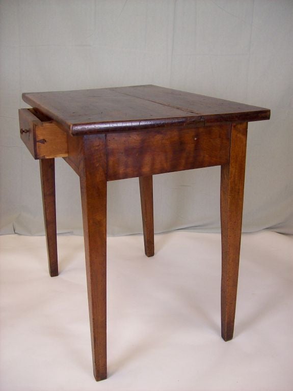 An antique side table from France. The walnut has extraordinary graining and color. One drawer.