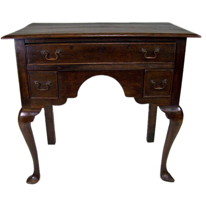 An 18th century Welsh lowboy and a Classic period oak piece. The dark oak of this console table has beautiful color, graining, and patina. Note the graceful front legs and the cockbeaded edges to the three drawers. Replaced handles in the original