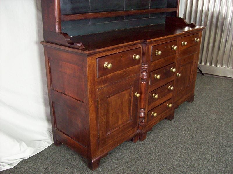 A very fine classic early dresser from Wales. This antique hutch, made of oak and fruit wood, has a beautiful color and patina. Note the shaped quarter columns on the base. The back of the top section is painted dark green,there are indents in the