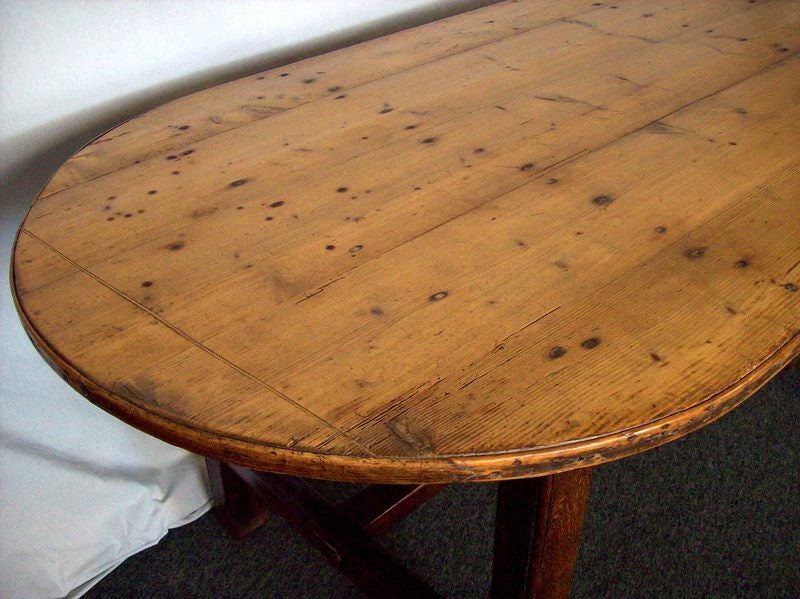 An antique rounded end farm table from France. The pine is a very pretty, deep, honey pine with a rich patina.  Very nice stretcher base is set in 11