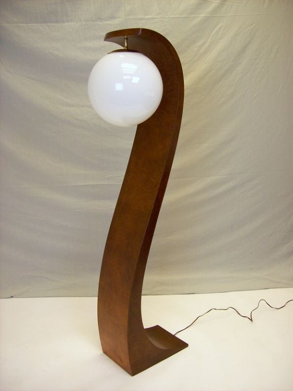 An S shaped cobra lamp from the 1960's, made in America.  The walnut veneer is in good condition.  Note the over-sized globe which gives off a soft light.  The switch is on the lower back of the piece.