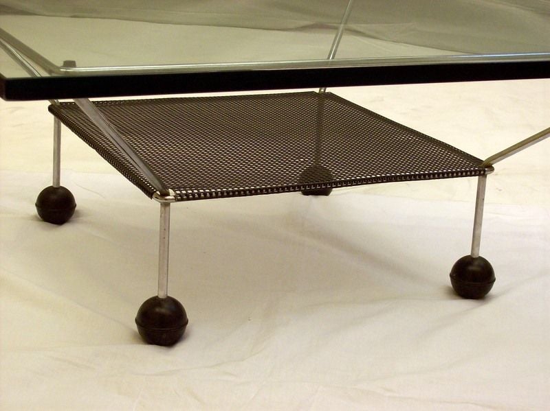 A large square glass top coffee table from the sixties, made in America.  Very interesting styling with the larger square over and above the smaller mesh square shelf.The 3/4