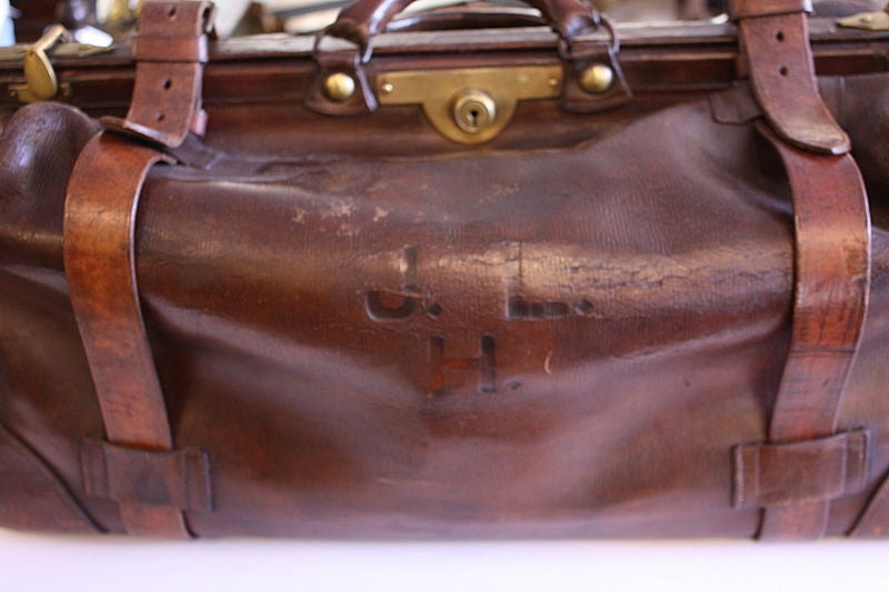 A handsome turn-of-the-century gladstone bag in rich brown leather.  Original brass lock and buckles with the initials 