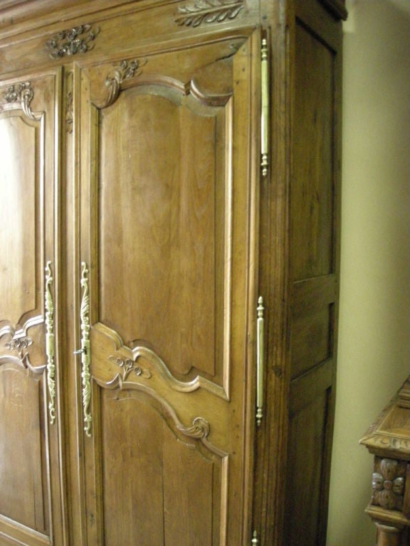 This handcarved chestnut armoire from Normandy is fitted with three (3) shelves (1.5