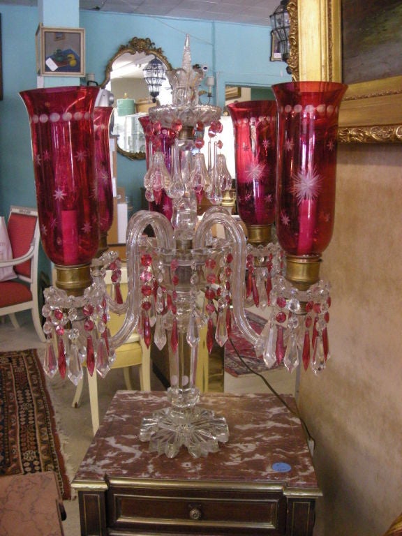 This Baccarat crystal, standing candelabra is wired for electric but can easily be reversed for candle fittings. The five (5) cranberry colored hurricane glass shades with etched stars and dots individually measure 11