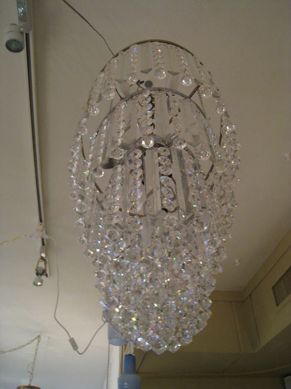 Four-tier Lobmeyr crystal chandelier. The bottom of the chandelier is covered with lucite from which faceted crystal hang to cover the interior of the chandelier. Sixteen lights.