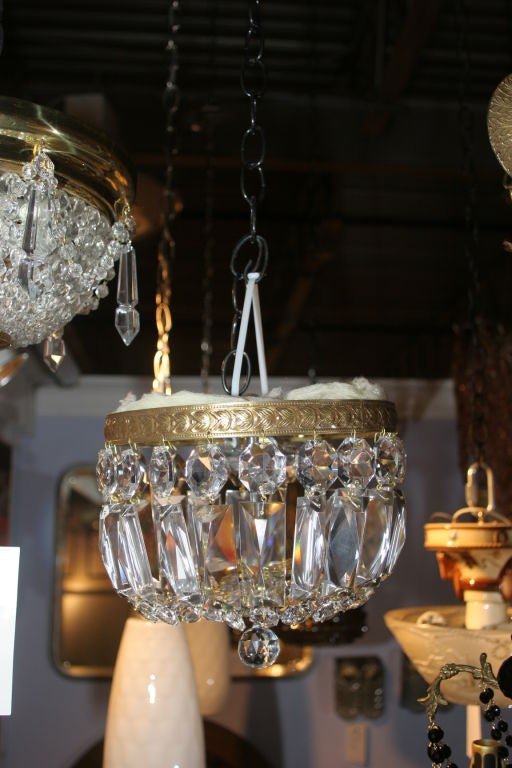 Crystal flush mounted chandelier.  Brass leaf trim design.  Crystal chain forming a basket.  Rescued from the old Boston Ritz Carlton Hotel. Three lights and the buyer should rewire it.  We recommend always rewiring unless we say it is rewired.  Put
