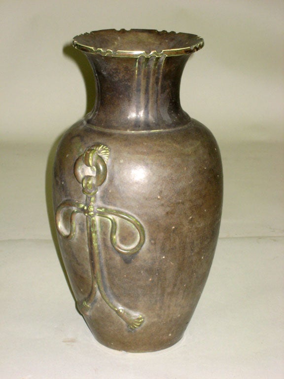 Un élégant vase émaillé avec deux symboles anthropomorphes en relief sur chaque face. Bonne taille.