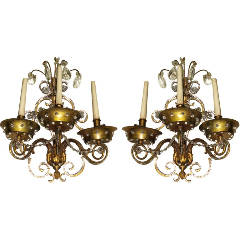 Elegant and timeless pair of modern neoclassical wall lights by Maison Jansen in the style of Louis XVI, each with three arms.

Each sconce has with a wood candle that lights. Additional lights are within each brass bobeche sending light upward and