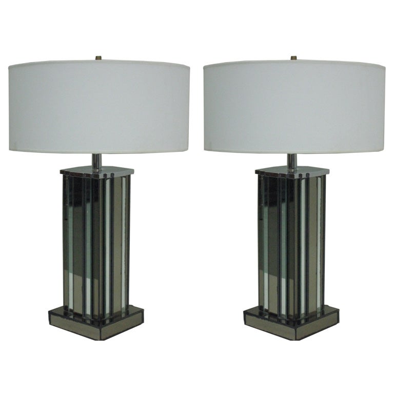 Pair of large Mid-Century Modern or Art Deco mirrored table lamps by Paul Frankl with alternating bands of silver and peach colored mirrored glass conveying the image of a skyscraper.

Shades are for demonstration only.