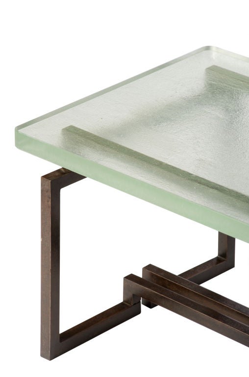 A low cocktail table with base realized of fer forgé and plateau of Saint-Gobain glass. Designed by Gilbert Poillerat (1902 - 1988) and Jacques Adnet (1901 - 1984) for the Company of French Arts.