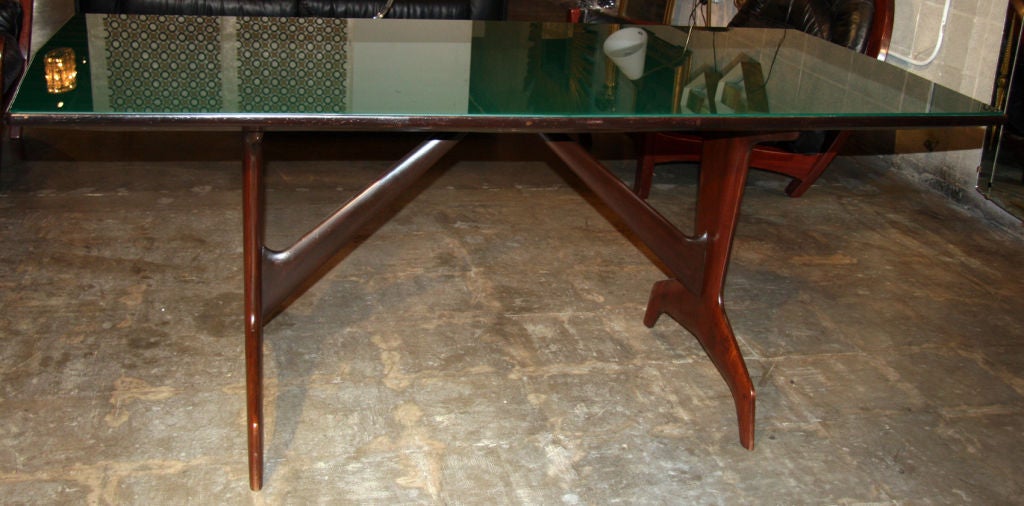 May be used as a dining table or terribly cool writing table. Pallisander base with green painted glass top. Match it up with original Carlo de Carli dining chairs (also available if you ask).