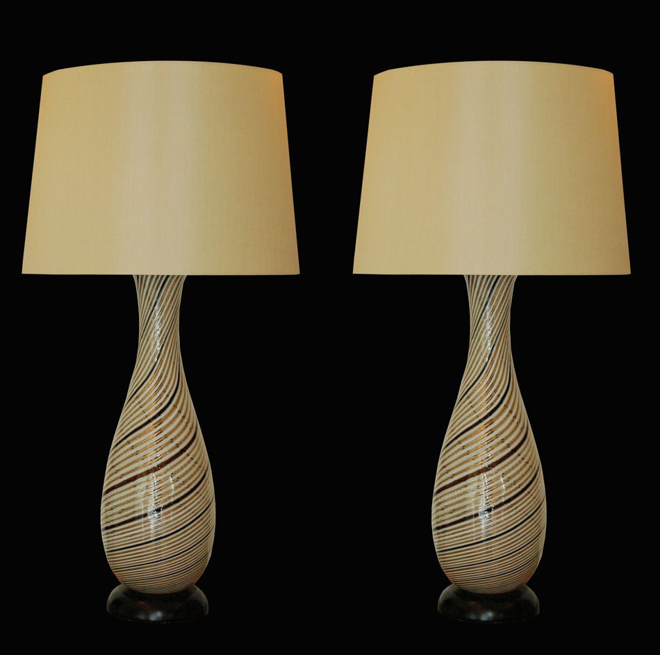 Strong pair of Dino Martens lamps for Aureliano Toso of Murano. Mezza filigrana pattern of opaque white, clear, brown and copper flake with ebonized wood bases.