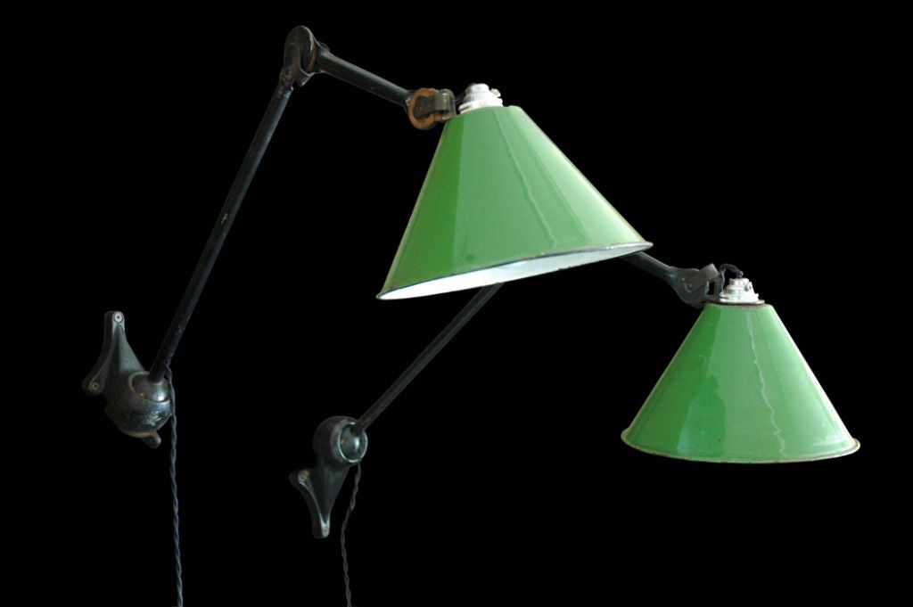 Unique pair of Gras Ravel lamps with green and white enameled shades.  Lamps have European sockets and have been rewired with cloth twist cord.  Lamps vary slightly from each other.  They are priced individually.