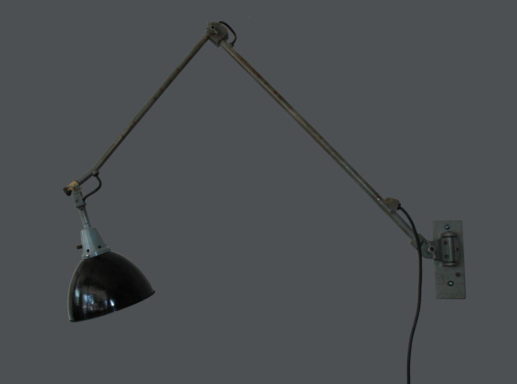 Large articulating wall light with black enameled shade; white on the interior.  Gray painted metal arms with brass details. Designed by Curt Fischer for Midgard.
