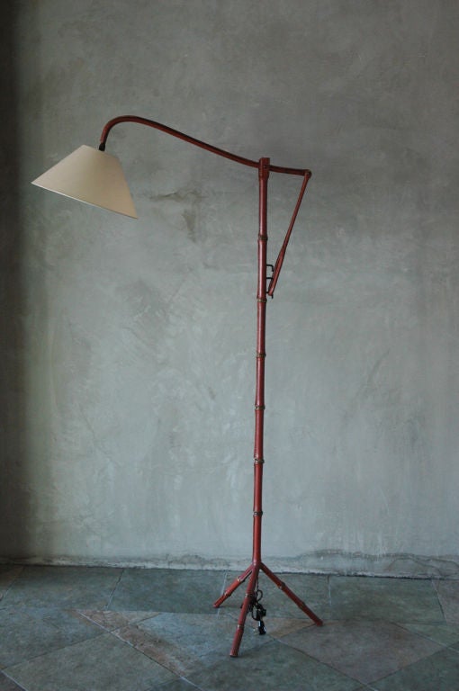 Adjustable floor lamp in hand stitched leather with tripod base by Jacques Adnet in collaboration with Hermes.