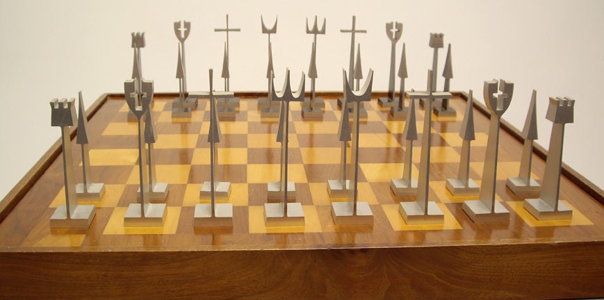 Chess set with chess table. Machined aluminum chess pieces made by Austin Enterprises 1962. Game table was purchased with the chess set. Included is the original wood and acrylic box to hold and display chess pieces. Table measures: 21 by 21 by 23